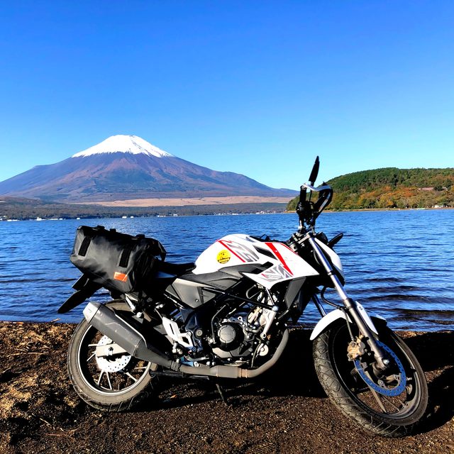 積読のページへ。富士山と湖を背にしたバイクの写真。読んだ本のカード一覧が開きます。